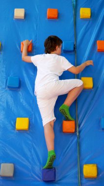      Çocuk şişme salıncağa tırmanıyor.                          