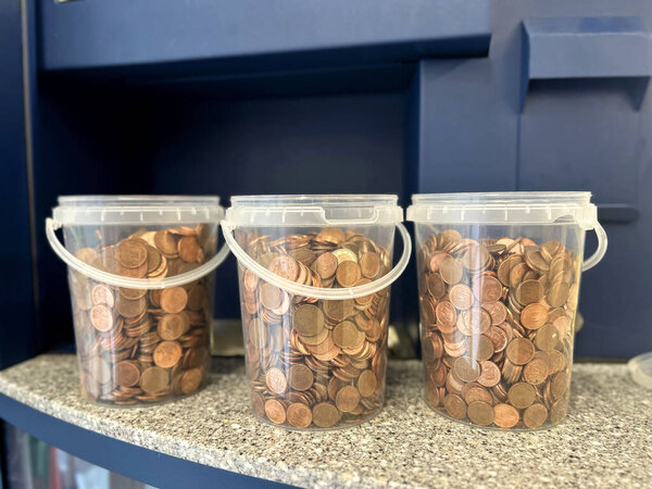 coins, small denominations, in plastic buckets for pouring into a money exchange machine