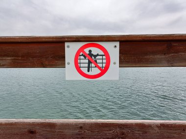 A sign on the lake bridge warning that jumping into water from the bridge is prohibited.pantano de Alloz .Navarra .Espaa April 5, 2024 clipart