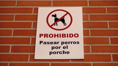       Bir iskan binasının tuğla duvarındaki tabela diyor ki: Verandada köpek gezdirmek yasaktır. Pamplona şehri 28 Nisan 2024 İspanya                         