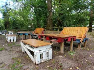 Ahşap Avrupa paletlerinden yapılmış, masaları olan bir dinlenme alanı. Konsept: ucuz, kullanılmış malzemelerin yaz tatili için kullanılması