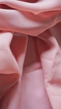 Pink silk background. The texture of the pink polycotton fabric is smooth and soft with beautiful close-up fabric details. Textile pattern with dense, breathable and flexible fibers.