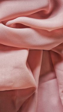 Pink silk background. The texture of the pink polycotton fabric is smooth and soft with beautiful close-up fabric details. Textile pattern with dense, breathable and flexible fibers.