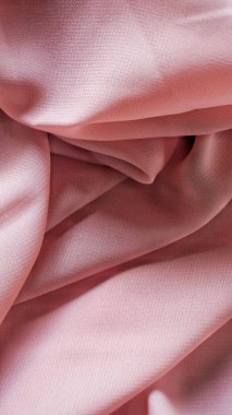 Pink silk background. The texture of the pink polycotton fabric is smooth and soft with beautiful close-up fabric details. Textile pattern with dense, breathable and flexible fibers.