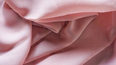 Pink silk background. The texture of the pink polycotton fabric is smooth and soft with beautiful close-up fabric details. Textile pattern with dense, breathable and flexible fibers.