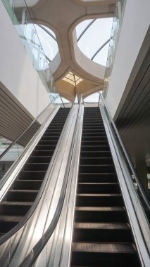 The escalator goes up and down inside the airport building.