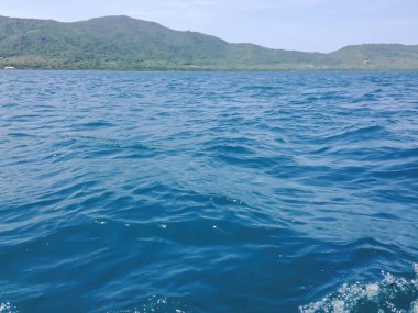 Beautiful view of the sea from the boat at sunny day. The pacific ocean  mountain background. Sea wave on the surface of the sea. 