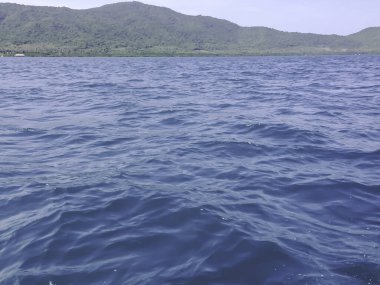 Beautiful view of the sea from the boat at sunny day. The pacific ocean  mountain background. Sea wave on the surface of the sea. 