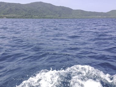 Beautiful view of the sea from the boat at sunny day. The pacific ocean  mountain background. Sea wave on the surface of the sea. 