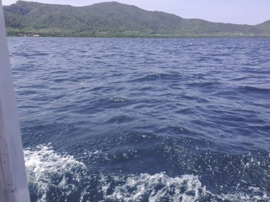 Beautiful view of the sea from the boat at sunny day. The pacific ocean  mountain background. Sea wave on the surface of the sea. 