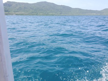 Beautiful view of the sea from the boat at sunny day. The pacific ocean  mountain background. Sea wave on the surface of the sea. 