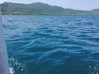 Beautiful view of the sea from the boat at sunny day. The pacific ocean  mountain background. Sea wave on the surface of the sea. 
