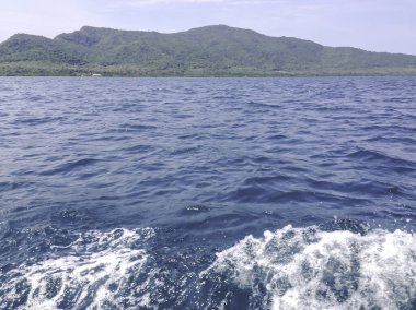 Beautiful view of the sea from the boat at sunny day. The pacific ocean  mountain background. Sea wave on the surface of the sea. 