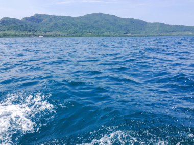 Beautiful view of the sea from the boat at sunny day. The pacific ocean  mountain background. Sea wave on the surface of the sea. 