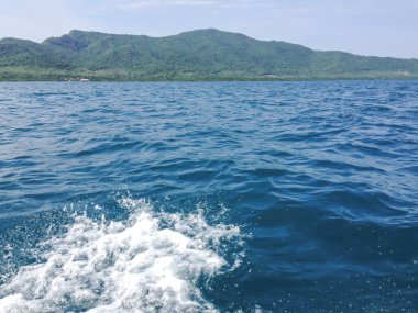 Beautiful view of the sea from the boat at sunny day. The pacific ocean  mountain background. Sea wave on the surface of the sea. 