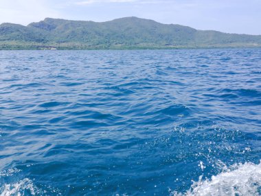 Beautiful view of the sea from the boat at sunny day. The pacific ocean  mountain background. Sea wave on the surface of the sea. 