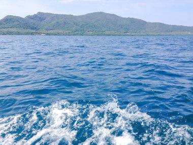 Beautiful view of the sea from the boat at sunny day. The pacific ocean  mountain background. Sea wave on the surface of the sea. 