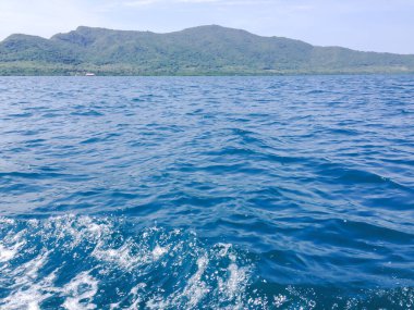 Beautiful view of the sea from the boat at sunny day. The pacific ocean  mountain background. Sea wave on the surface of the sea. 
