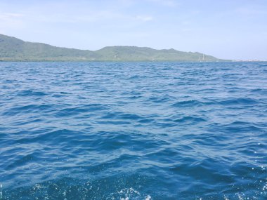 Beautiful view of the sea from the boat at sunny day. The pacific ocean  mountain background. Sea wave on the surface of the sea. 