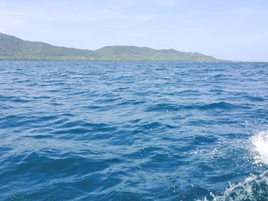 Güneşli bir günde tekneden güzel bir deniz manzarası. Pasifik Okyanusu Dağı arka planı. Denizin yüzeyindeki deniz dalgaları. 