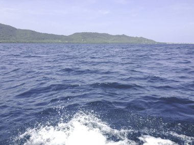 Beautiful view of the sea from the boat at sunny day. The pacific ocean  mountain background. Sea wave on the surface of the sea. 