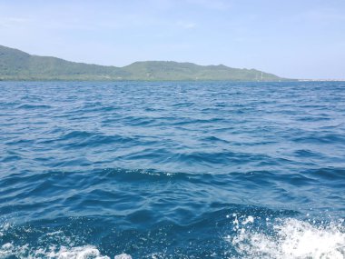 Güneşli bir günde tekneden güzel bir deniz manzarası. Pasifik Okyanusu Dağı arka planı. Denizin yüzeyindeki deniz dalgaları. 