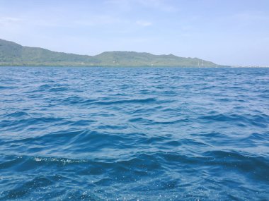 Beautiful view of the sea from the boat at sunny day. The pacific ocean  mountain background. Sea wave on the surface of the sea. 