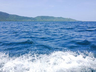 Beautiful view of the sea from the boat at sunny day. The pacific ocean  mountain background. Sea wave on the surface of the sea. 