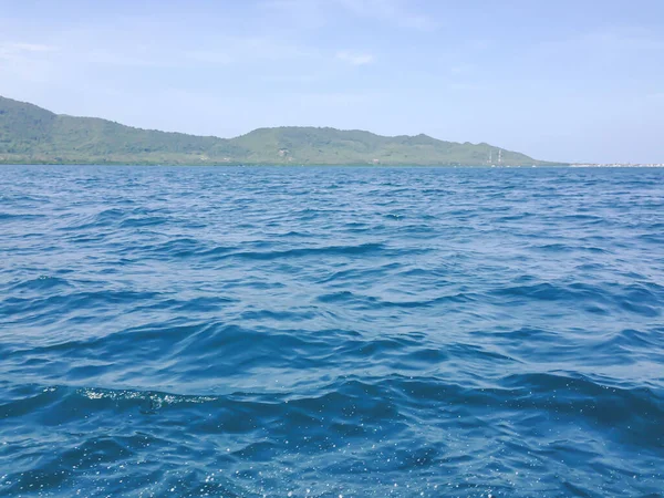 Güneşli bir günde tekneden güzel bir deniz manzarası. Pasifik Okyanusu Dağı arka planı. Denizin yüzeyindeki deniz dalgaları. 