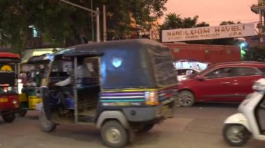 JAIPUR, INDIA - 10 AĞUSTOS 2019: Vibrant cadde trafiği Jaipur, Hindistan 'da gece vakti popüler bir pazarın önünden geçiyor