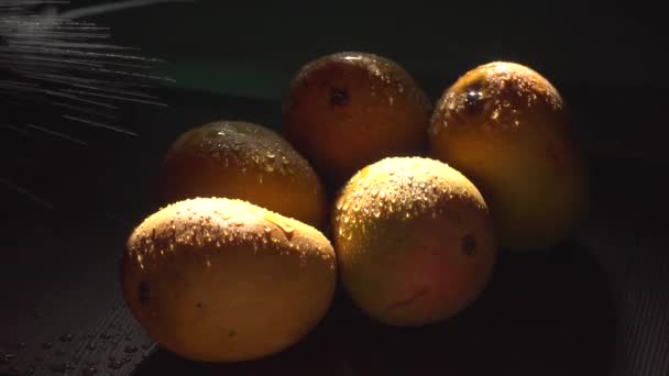 黑暗中向新鲜芒果喷水的演播室镜头 — 图库视频影像