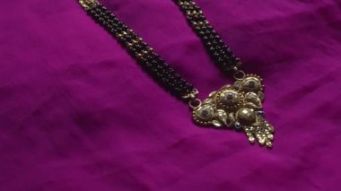 Mor arka planda harika altın bir kolye