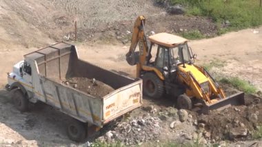 İnşaat alanındaki kazıcı ve kamyonun görüntüsü