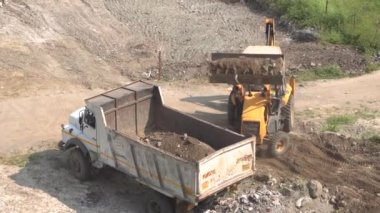 İnşaat alanındaki kazıcı ve kamyonun görüntüsü