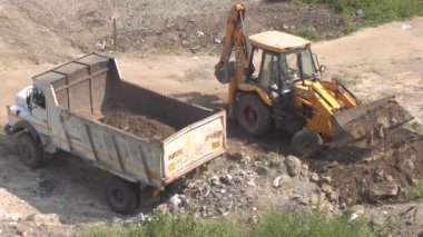 İnşaat alanındaki kazıcı ve kamyonun görüntüsü