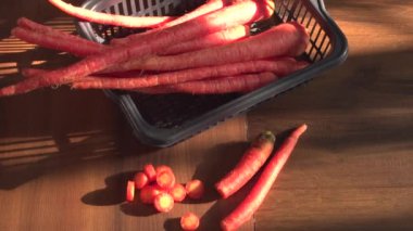 fresh sweet carrot in basket on wooden background, close up view