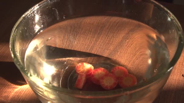 Φέτες Καρότα Που Υπάγονται Στο Μπολ Νερό Κοντά Προβολή — Αρχείο Βίντεο