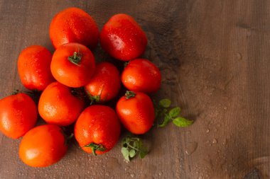 Tahta masada olgun ve ıslak kırmızı domatesler.
