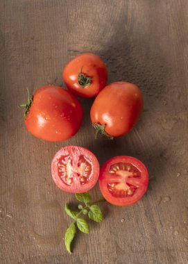 Tahta masada olgun ve ıslak kırmızı domatesler.