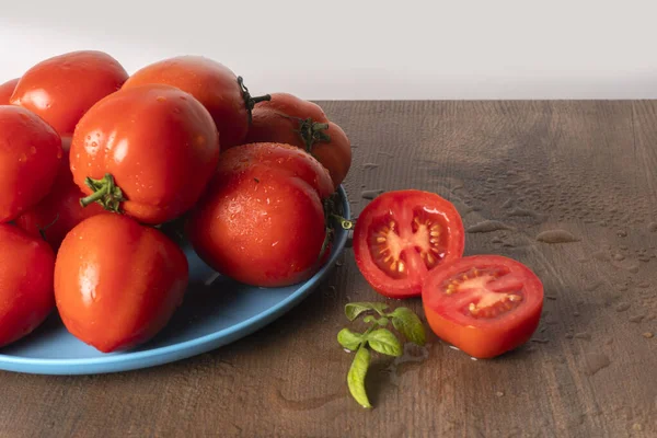 Mogna Och Våta Röda Tomater Blå Tallrik Träbord — Stockfoto