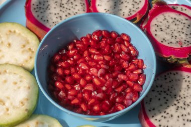 Tabakta kabak ve nar tohumlarıyla dilimlenmiş ejderha meyvesi.