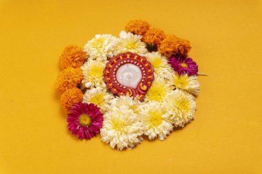 Sarı zemin üzerinde mum bulunan güzel çiçeklerin yakın çekimi.