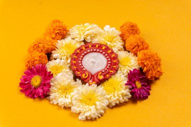 Sarı zemin üzerinde mum bulunan güzel çiçeklerin yakın çekimi.