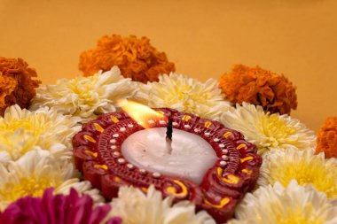 Sarı zemin üzerinde mum bulunan güzel çiçeklerin yakın çekimi.