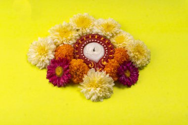 Sarı zemin üzerinde mum bulunan güzel çiçeklerin yakın çekimi.