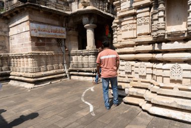 Tapınak arka planında poz veren yakışıklı Hintli adam.