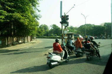 Pune, India - 19 January 2020: Daily traffic and city life on the busy streets during a beautiful golden sunset.