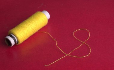 yellow sewing thread on red background
