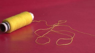 yellow sewing thread on red background