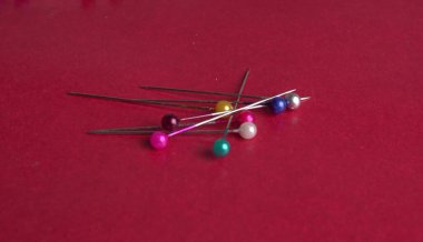 close up of sewing pins on red background